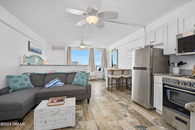 800 N Atlantic Ave Unit 523, Daytona Beach, FL 32118 - living area featuring a textured ceiling, light wood-type flooring, and a ceiling fan