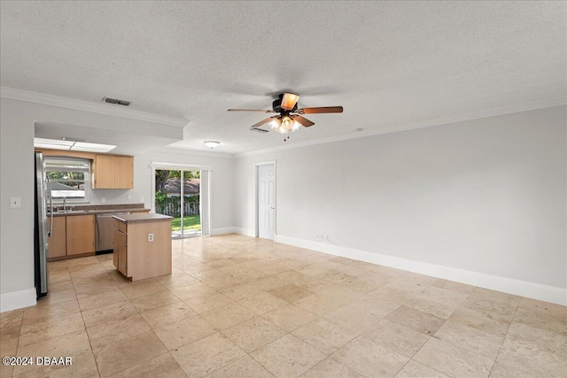 kitchen with stainless steel appliances, plenty of natural light, sink, and a center island