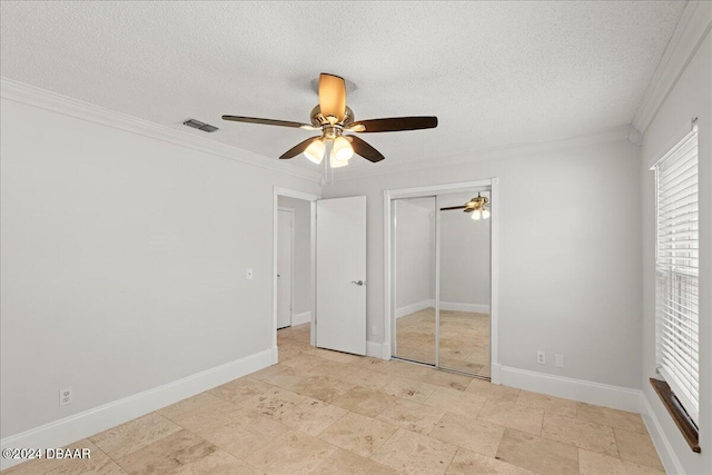 unfurnished bedroom featuring ceiling fan, a textured ceiling, a closet, and ornamental molding