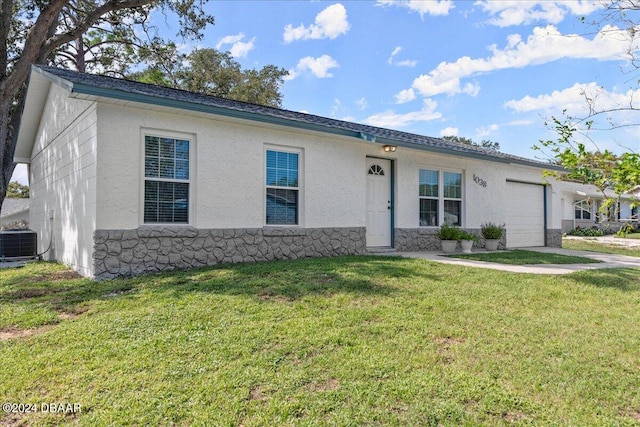 ranch-style home featuring central AC unit, a front yard, and a garage