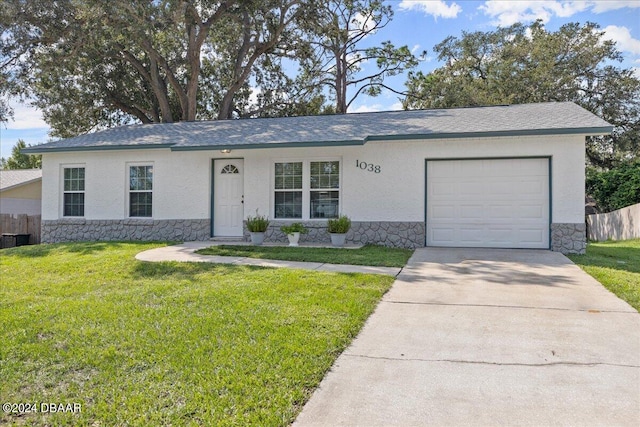 ranch-style home with a garage and a front lawn