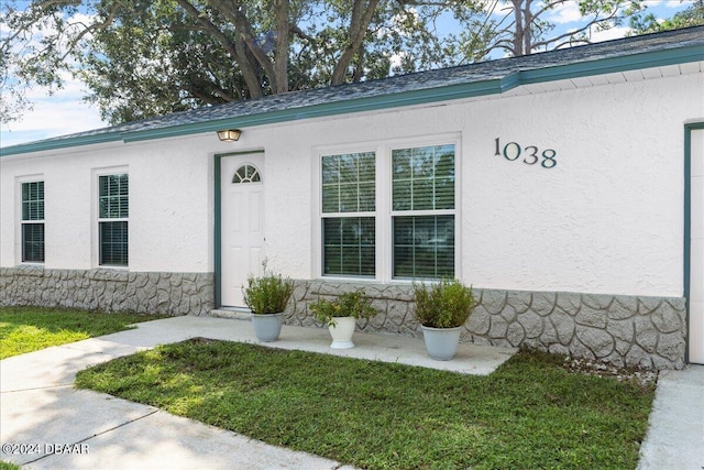 property entrance featuring a lawn