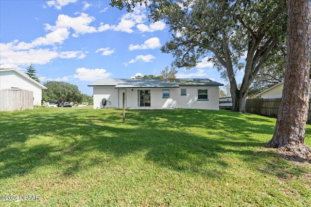 back of house featuring a lawn