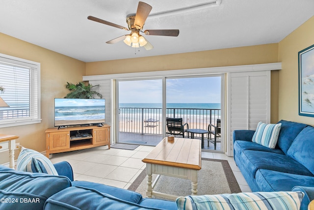 living room featuring a textured ceiling, a healthy amount of sunlight, ceiling fan, and light tile patterned floors