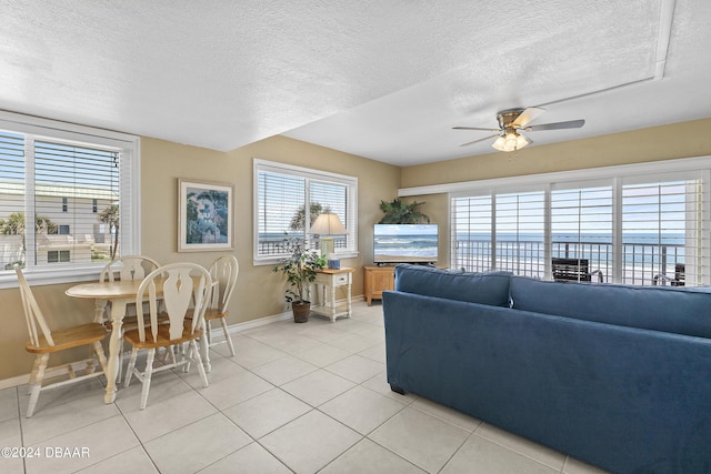815 Ocean Shore Blvd Unit U1B, Ormond Beach, FL 32176 - living room with baseboards, ceiling fan, a textured ceiling, and light tile patterned flooring
