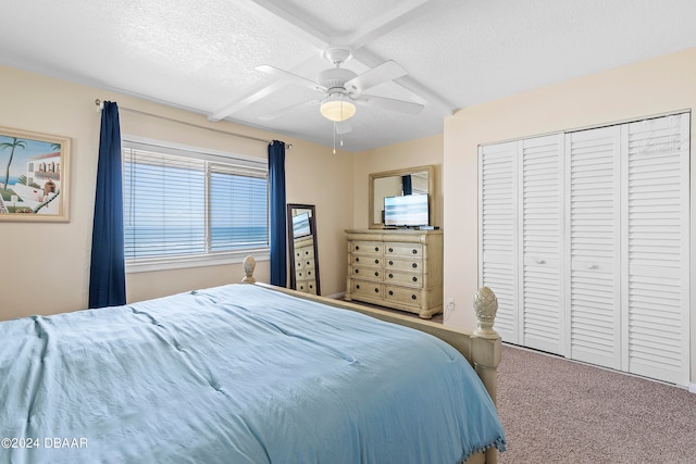 carpeted bedroom featuring a textured ceiling, ceiling fan, and a closet