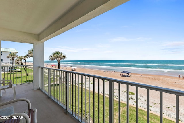 balcony featuring a view of the beach and a water view