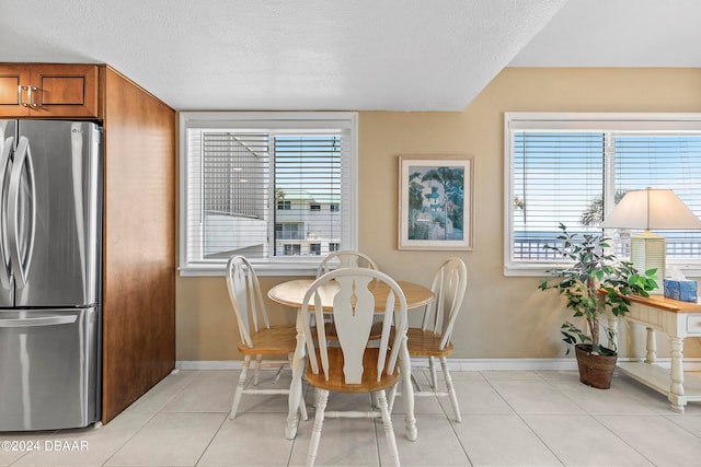 tiled dining space with a wealth of natural light and a textured ceiling