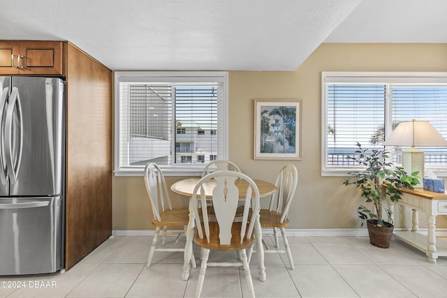 815 Ocean Shore Blvd Unit U1B, Ormond Beach, FL 32176 - dining area featuring light tile patterned floors, plenty of natural light, a textured ceiling, and baseboards