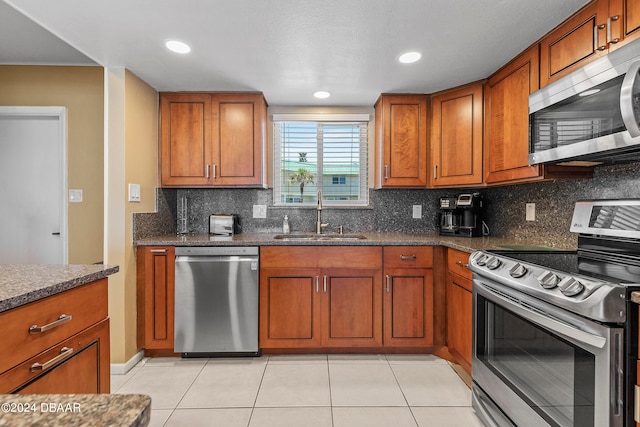 kitchen featuring light tile patterned flooring, sink, appliances with stainless steel finishes, and tasteful backsplash