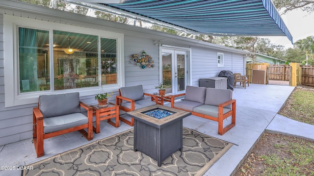 view of patio featuring an outdoor living space with a fire pit, french doors, and fence