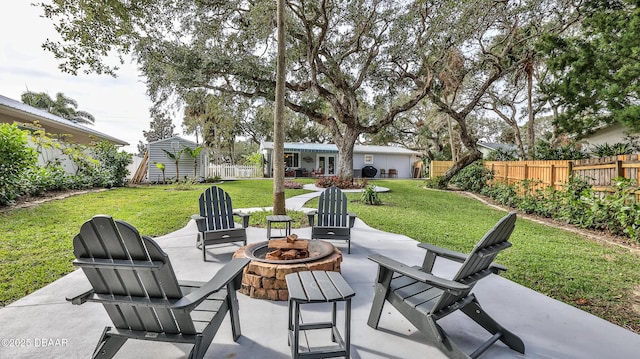 view of patio / terrace featuring a fire pit, an outbuilding, and fence