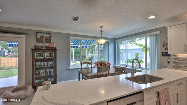 kitchen featuring a sink, visible vents, dishwasher, and white cabinetry