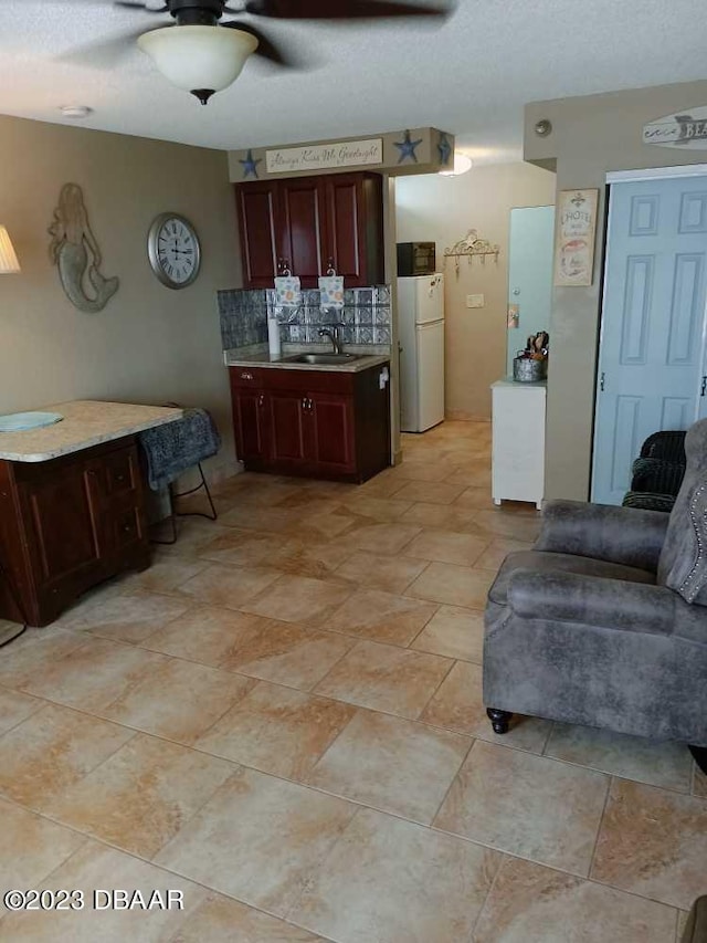 kitchen featuring sink, ceiling fan, decorative backsplash, and white fridge