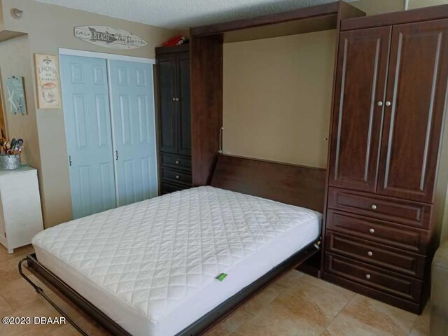 tiled bedroom featuring a textured ceiling