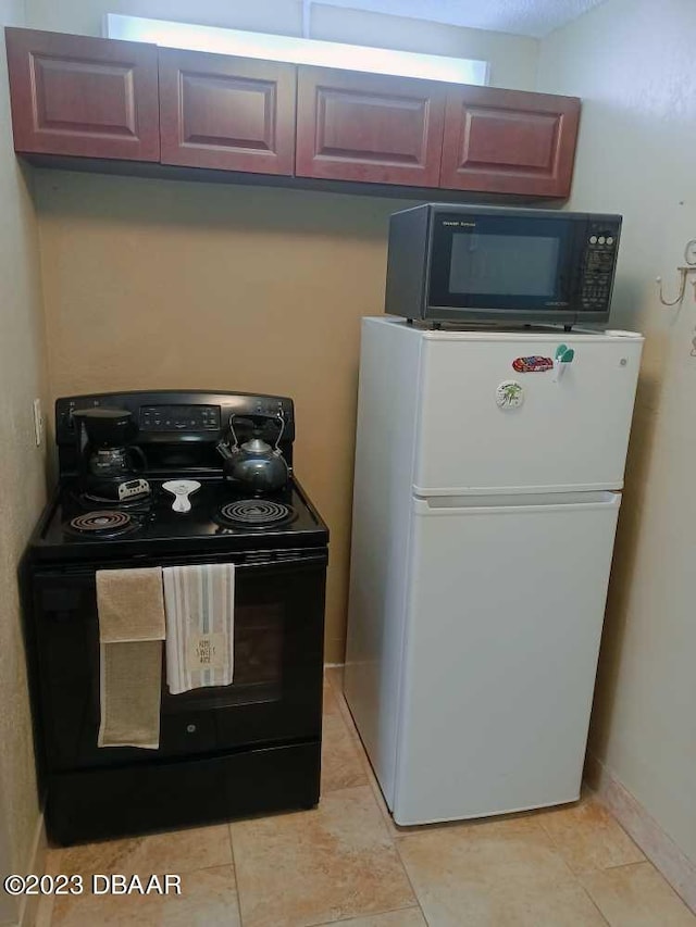 kitchen with light tile patterned flooring and black appliances