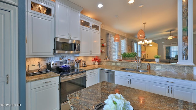 3368 Marsili Ave, New Smyrna Beach, FL 32168 - kitchen featuring appliances with stainless steel finishes, ornamental molding, tasteful backsplash, white cabinets, and glass insert cabinets