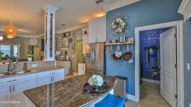 3368 Marsili Ave, New Smyrna Beach, FL 32168 - kitchen with stainless steel fridge, white cabinets, dark stone counters, ceiling fan, and light tile patterned floors