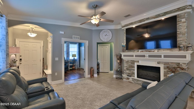 3368 Marsili Ave, New Smyrna Beach, FL 32168 - living area featuring a ceiling fan, arched walkways, tile patterned floors, crown molding, and a fireplace