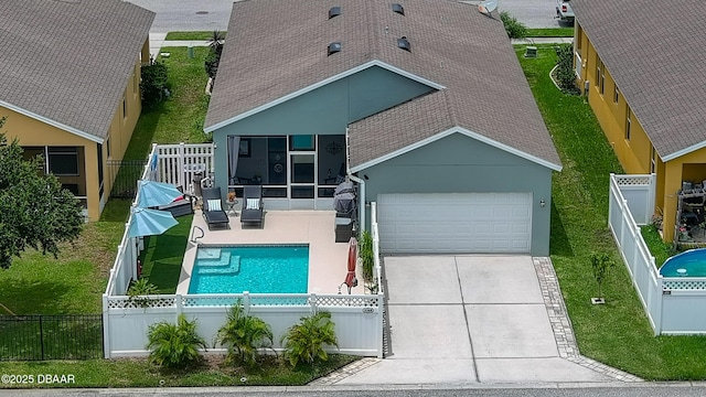3368 Marsili Ave, New Smyrna Beach, FL 32168 - view of front of home featuring roof with shingles, a sunroom, concrete driveway, a fenced front yard, and a garage