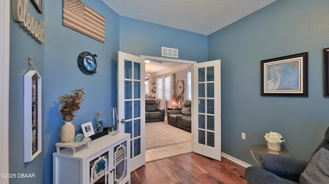 3368 Marsili Ave, New Smyrna Beach, FL 32168 - living area featuring french doors, dark wood-type flooring, and a textured ceiling