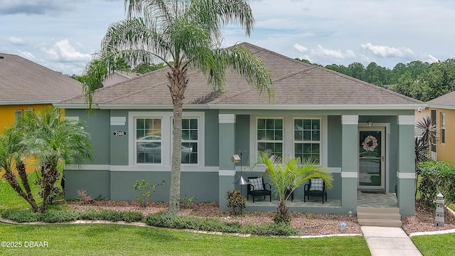 3368 Marsili Ave, New Smyrna Beach, FL 32168 - view of front of home featuring stucco siding, covered porch, a front lawn, and a shingled roof