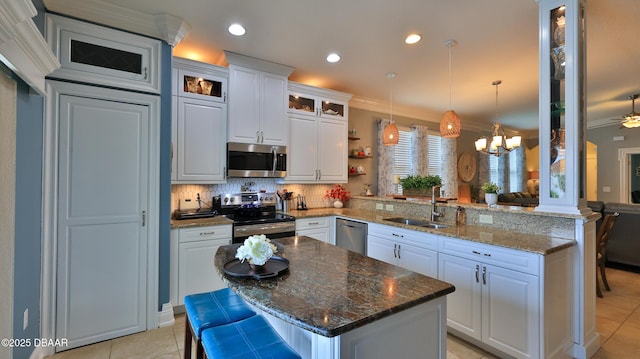 3368 Marsili Ave, New Smyrna Beach, FL 32168 - kitchen with stainless steel appliances, a peninsula, light tile patterned flooring, crown molding, and a chandelier