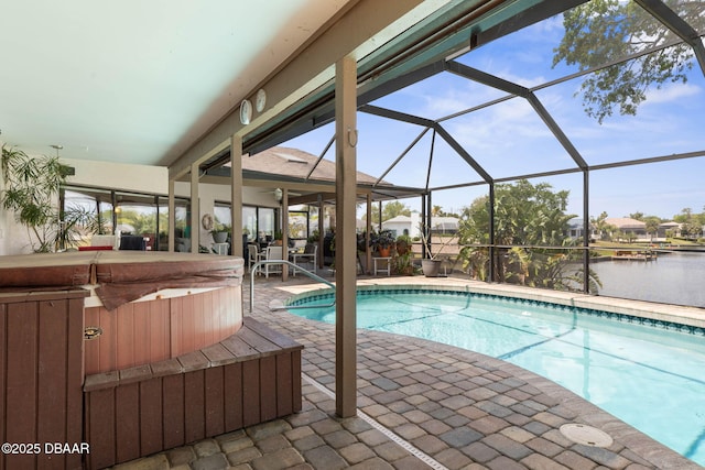 outdoor pool with a lanai, a patio, a covered hot tub, and a water view