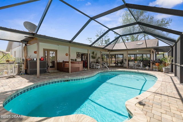 outdoor pool featuring a patio area, glass enclosure, and a hot tub