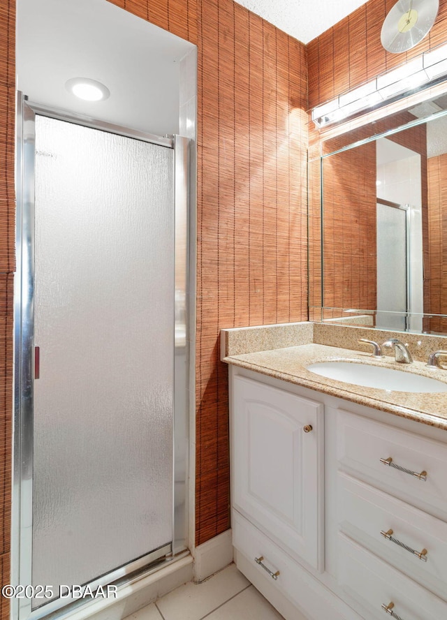 bathroom with tile patterned floors, vanity, and a stall shower