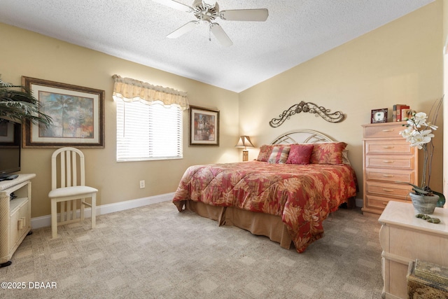 bedroom with a textured ceiling, ceiling fan, and light carpet