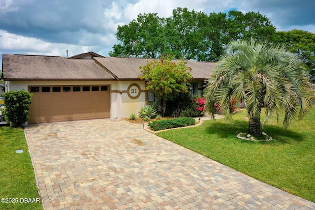 ranch-style home with a garage, stucco siding, a front lawn, decorative driveway, and roof with shingles