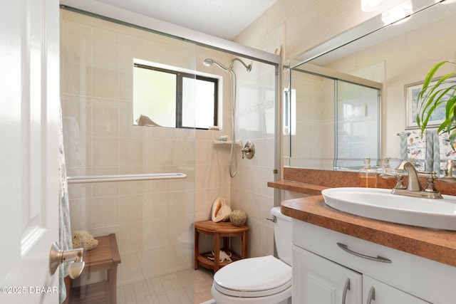 bathroom with a shower stall, toilet, vanity, and tile walls