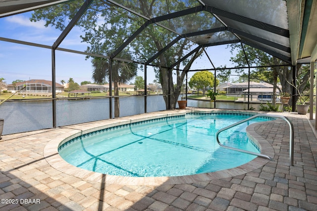 outdoor pool featuring a lanai, a patio area, a residential view, and a water view