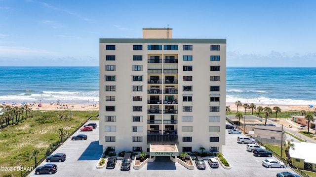 view of building exterior with a beach view and a water view