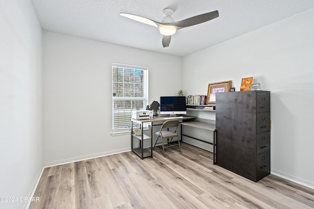 home office with a textured ceiling, light hardwood / wood-style floors, and ceiling fan