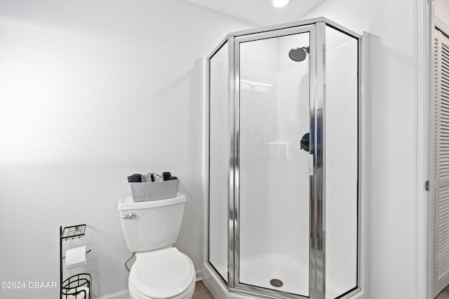 bathroom featuring an enclosed shower and toilet