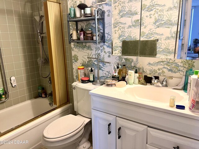 935 N Halifax Ave Unit 907, Daytona Beach, FL 32118 - bathroom featuring toilet, vanity, bath / shower combo with glass door, and wallpapered walls