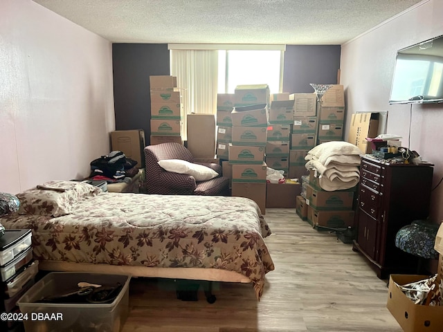 bedroom with light hardwood / wood-style floors and a textured ceiling