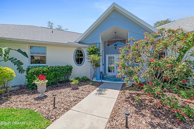 203 Prestwick Dr, New Smyrna Beach, FL 32168 - property entrance featuring stucco siding and a shingled roof