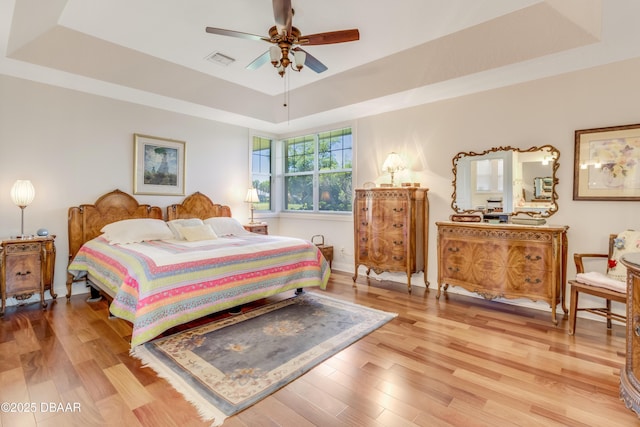 203 Prestwick Dr, New Smyrna Beach, FL 32168 - bedroom with a tray ceiling and light wood-style floors