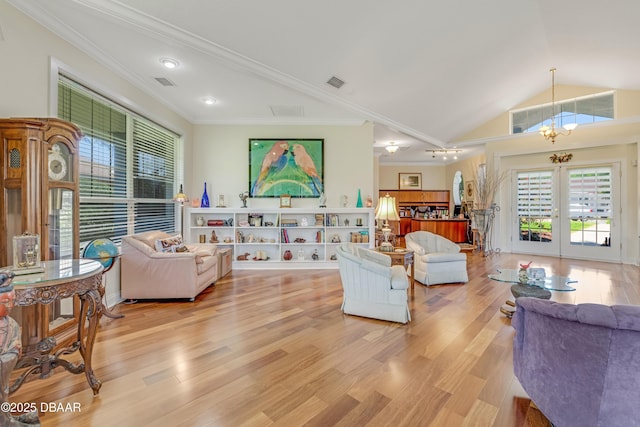 203 Prestwick Dr, New Smyrna Beach, FL 32168 - living area with a chandelier, light wood finished floors, vaulted ceiling, french doors, and ornamental molding