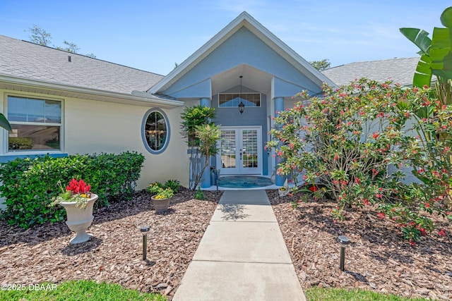 203 Prestwick Dr, New Smyrna Beach, FL 32168 - doorway to property with french doors, roof with shingles, and stucco siding