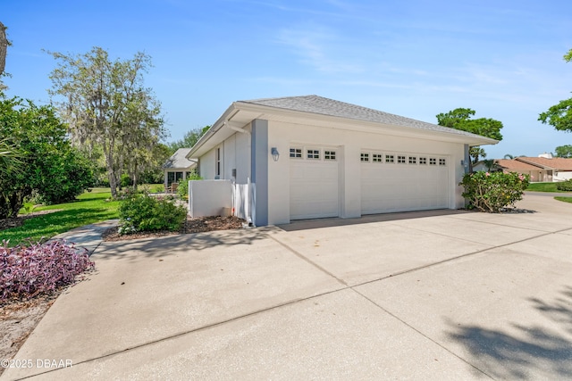 203 Prestwick Dr, New Smyrna Beach, FL 32168 - view of side of home featuring stucco siding, driveway, and a garage