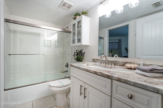 full bathroom featuring toilet, combined bath / shower with glass door, vanity, and tile patterned floors