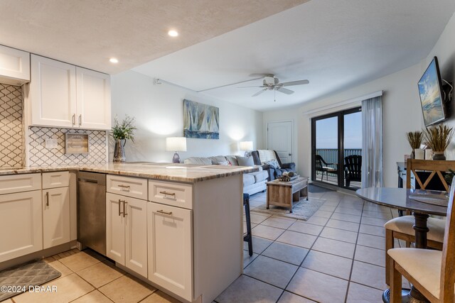 kitchen featuring white cabinets, kitchen peninsula, light tile patterned floors, ceiling fan, and backsplash