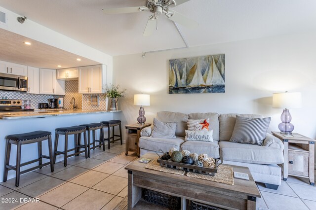 tiled living room featuring sink and ceiling fan