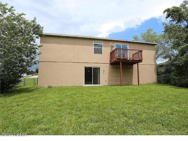 rear view of house with a yard and a wooden deck