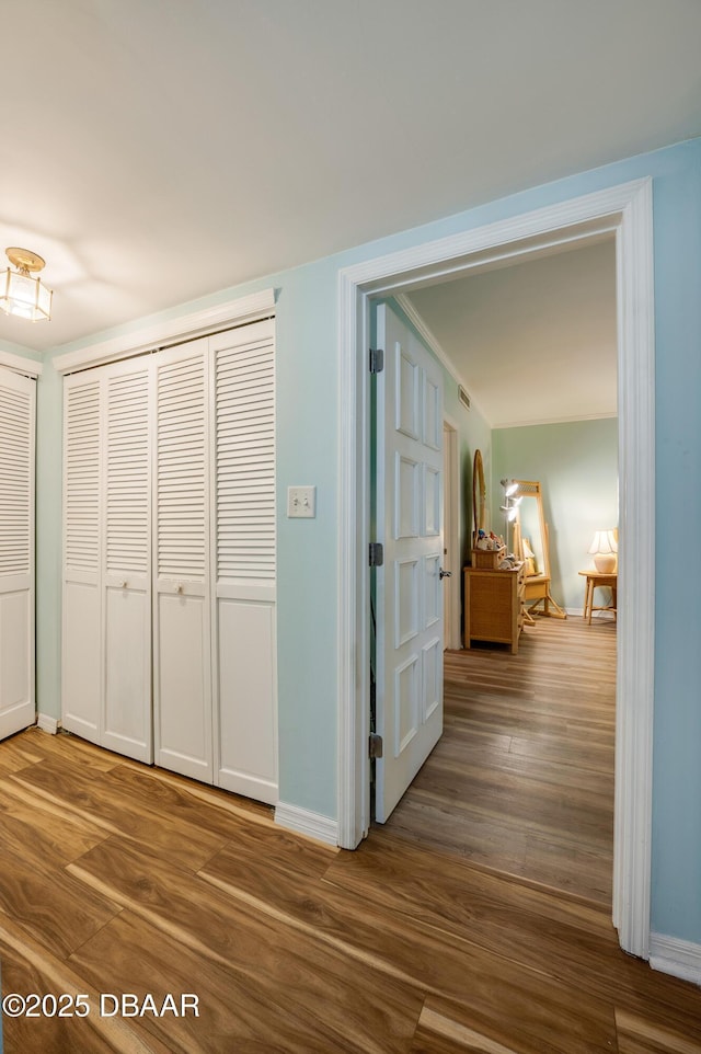 hall with baseboards and wood finished floors