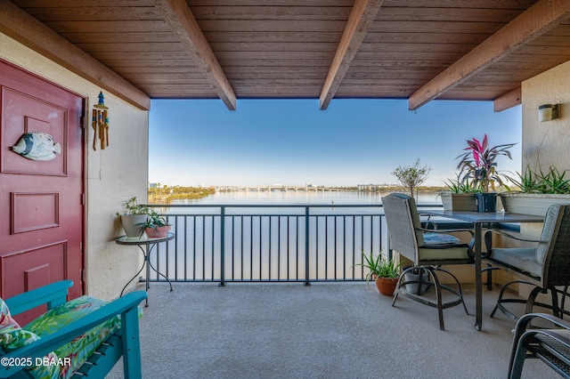 balcony featuring outdoor dining space and a water view